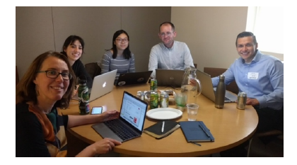 Photo of study researchers sitting together at a table with laptops.